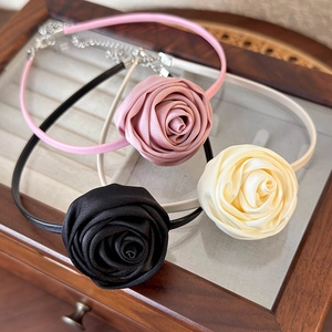 Three handmade satin rose chokers in pink, black, and beige with adjustable metal chains