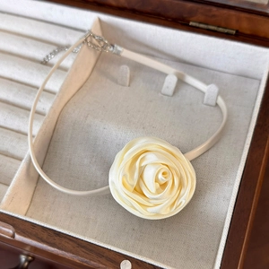 Detail of cream silk rose choker necklace with adjustable silver clasp in jewelry box