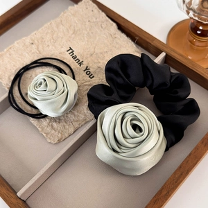 Detailed macro view of mint green silk roses on elastic hair ties and scrunchies