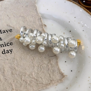 Detailed macro of a pearl telephone wire hair tie on a decorative ceramic tray