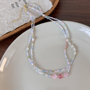 Dettaglio della collana a doppio strato con perline colorate, stelle e perle su vassoio