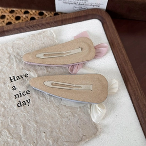 Détail de barrettes à nœuds en tissu de style ballet rose et bleu-gris sur un plateau