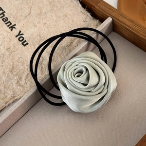 Macro detail of silk texture on mint green rose hair tie with elastic band