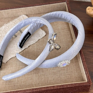 Detailed macro view of handmade light blue satin headbands with rhinestone butterflies