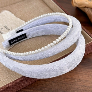Detail of floral jacquard wide headband with pearl hairband set in a display tray