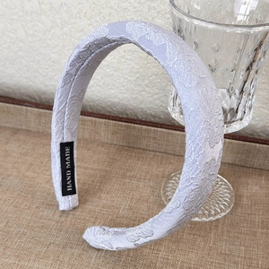 Detailed close-up of light purple floral jacquard headband with HAND MADE label