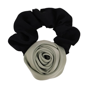 Mint green fabric rose hair tie with black pleated elastic scrunchie on white background