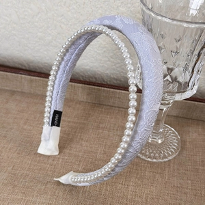 Detailed macro of French style headband featuring purple lace and faux pearl trim