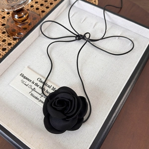 Détail du tour de cou rose satin noire élégante avec cordon sur plateau à bijoux