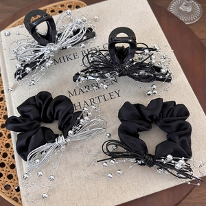 Elegant 4-piece black hair accessory set with silver bead bow design on a book background