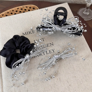 Detail of black and silver hair accessories set with bowknot accents on vintage books