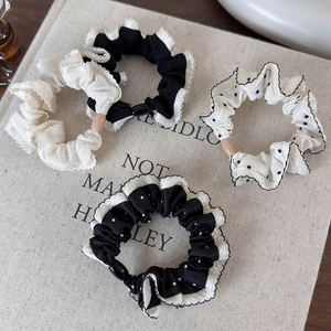 Detailed set of four lace and polka dot scrunchies with matte beads on soft fabric
