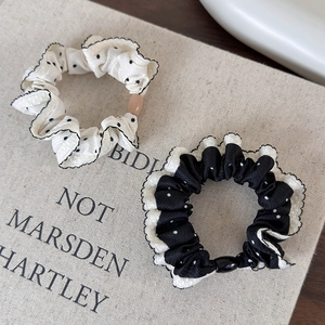 Detailed view of polka dot scrunchies with contrast ruffle edges on vintage book