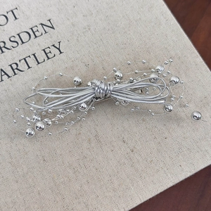 Detailed macro view of silver beaded butterfly hair clip with metallic wire weaving