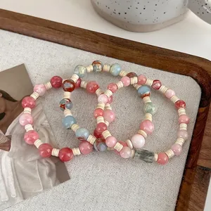 Pink bohemian beaded bracelets with faux stone texture in a decorative wooden tray