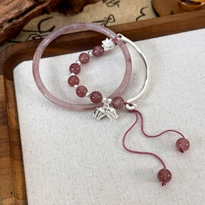 Détail du charme de muguet sur le bracelet en cristal de fraise et le jonc marbré poli
