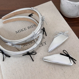 Detailed set of silver leather bow headbands and clips on an elegant book background