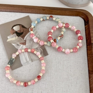 Set of three colorful handmade beaded bracelets with faux Shoushan stone in a wooden tray