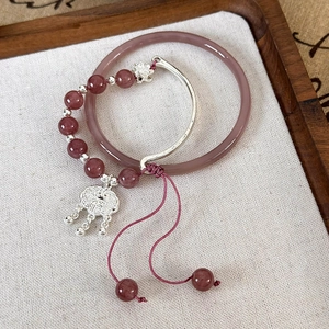 Détail de l'ensemble bracelet en calcédoine rouge avec pendentif cadenas et signe Fu