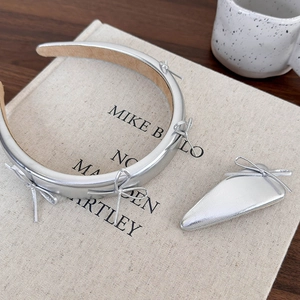 Silver bow headband and triangle clip set with metallic leather texture on book