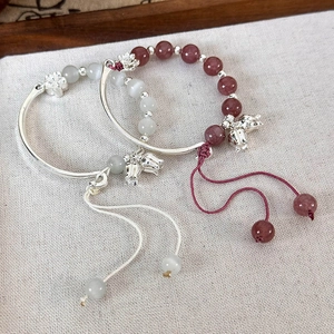 Détail du bracelet muguet avec pierre œil de chat et breloques en argent ciselé