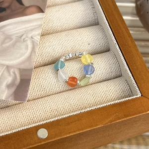 Anello con perline colorate a cuore e dettagli in argento in una scatola regalo