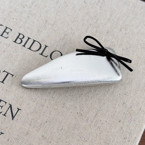 Macro detail of silver metallic leather headband with elegant black ribbon bow accent