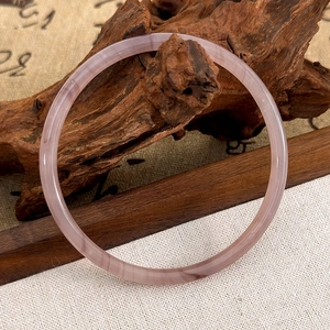 Gros plan détaillé d'un bracelet en agate violette posé sur un décor en bois rétro