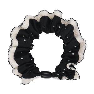 Polka dot hair scrunchie with white ruffle edges and black plastic buckle on white background