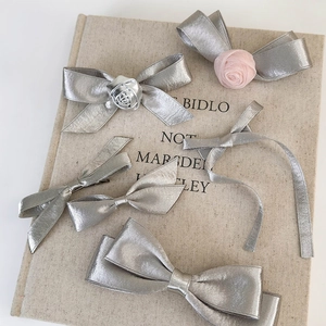 5-piece silver satin ribbon hair clips set with rose decor on vintage book background