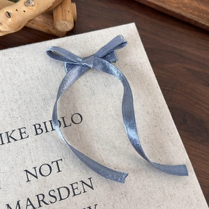 Détail d'un élégant nœud à cheveux bleu poudré avec de longs rubans sur fond en toile