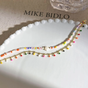 Detail of colorful double-layered beaded bracelet with a star pendant and golden charms
