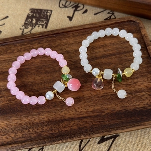 Bracelets de perles pêche avec cristaux roses et perles sur un support en bois
