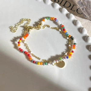 Detail of colorful double-layered beaded bracelet with gold chain and lobster clasp