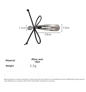 Détail de la pince à cheveux avec cœur, nœud noir et dimensions de 5,8 cm