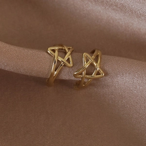 Vue détaillée de boucles d'oreilles étoiles dorées sur un tissu élégant en soie champagne