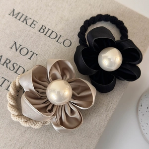 Elegant camellia flower hair ties with large pearls and satin petals in black and champagne
