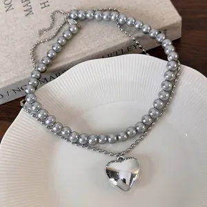 Collier double rang avec pendentif cœur argenté et perles grises sur platine en porcelaine