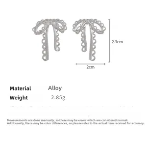 Detailed view of silver bow earrings showing alloy material and 2.3cm by 2cm dimensions