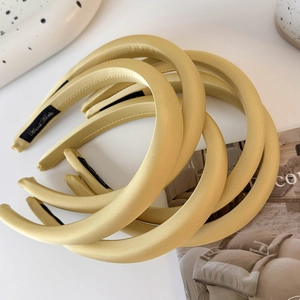 Vue détaillée du serre-tête en satin champagne fait main avec une texture premium