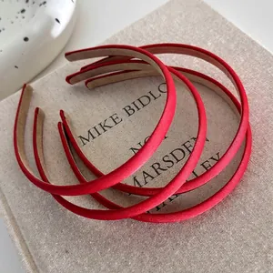 Set of 5 red satin minimalist thin headbands for women on a textured linen book