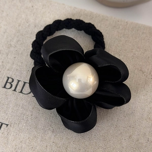 Close-up of black satin camellia hair scrunchie with large pearl centerpiece