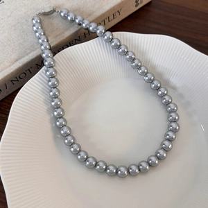 Vue détaillée de perles gris argenté brillantes dans un collier élégant au lustre métallique