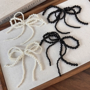 Vue détaillée des breloques de chaussures en perles et perles noires avec pompon