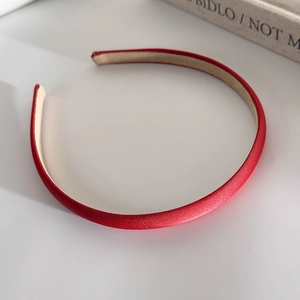 Detail view of a slim red leather headband featuring premium texture and anti-slip lining