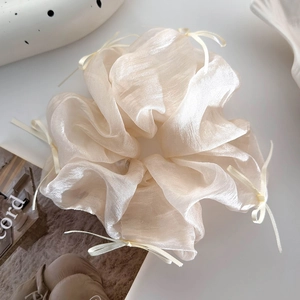 Dettaglio dell'elastico per capelli in organza champagne con fiocchi di nastro sottili