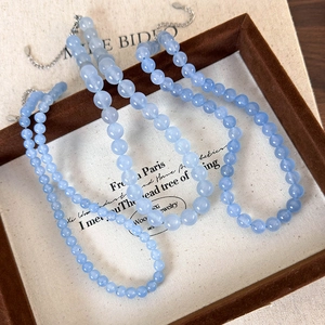 Detail of blue beaded necklace featuring sea blue gemstones and adjustable metal clasp