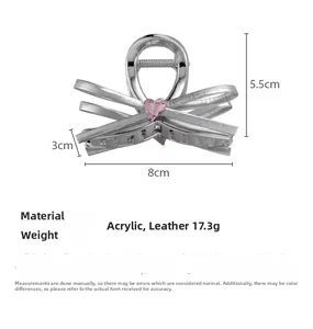 Detailsicht der silbernen Schleifen-Haarklammer mit rosa Herz-Strass und Lederstruktur