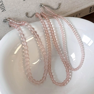Detail view of pink glass beaded necklaces with metal lobster clasp and extension chain