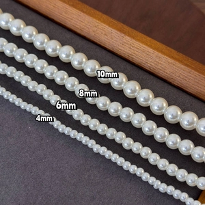 Lustrous white pearl necklaces in 4mm to 10mm sizes displayed on a premium dark board
